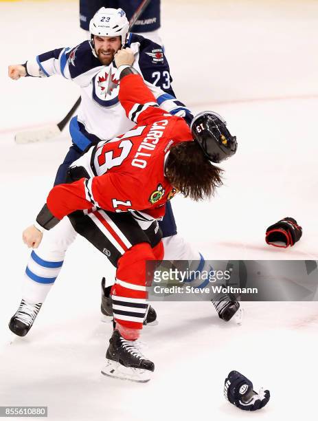 Jay Harrison of the Winnipeg Jets fights Daniel Carcillo of the Chicago Blackhawks in during a game at the United Center on December 23, 2014 in...