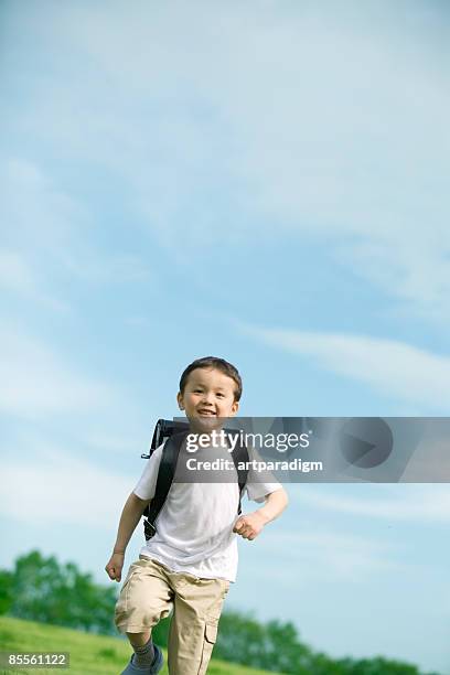 a boy running on grass - school boy with bag stock pictures, royalty-free photos & images