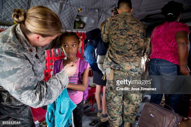 Air Force Major Lisa Ray attends to girls as she is been evacuated from Dominica on September 27, 2017 aboard a CH47 Army Joint Task Force Leeward...