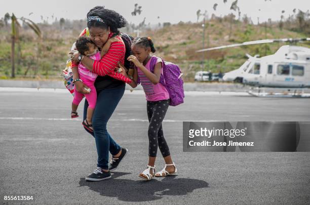 Woman carries her baby and daughter as they evacuate from Dominica on September 27,2017 aboard a CH47 Army helicopter, part of the Joint Task Force...