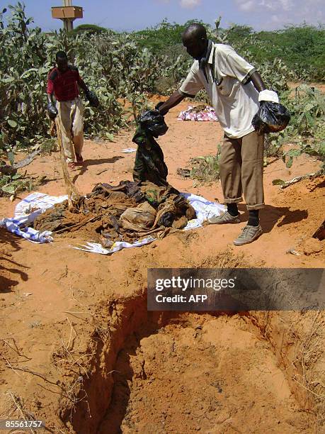 Somali men stand by the remains on March 22, 2009 of individuals that were allegedly shot by Ethiopian troops during their occupation of parts of...