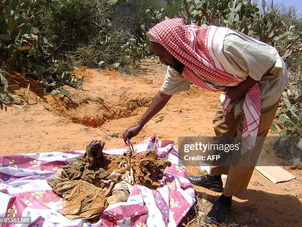 Somali man looks over the remains on March 22, 2009 of individuals that were allegedly shot by Ethiopian troops during their occupation of parts of...