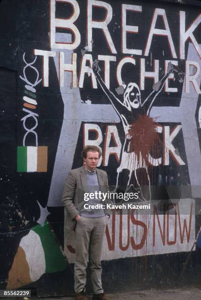 Martin McGuinness, an alleged IRA chief of staff, stands in front of an anti-Margaret Thatcher mural on the corner of Falls road, the heart of the...