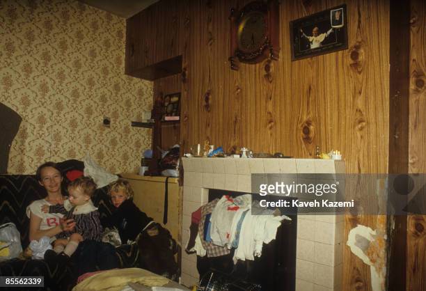 Mother and her two children sit on the sofa of their the living room in the Catholic residential area of west Belfast, 18th September 1985. A picture...