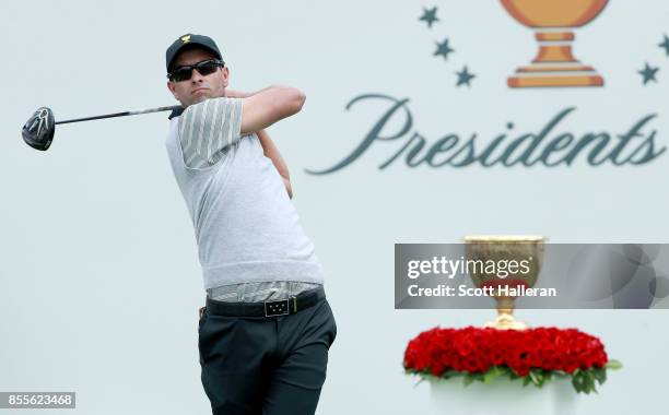 Adam Scott of Australia and the International Team plays his shot from the first tee during the Friday four-ball matches during the second round of...