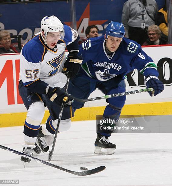 David Perron of the St. Louis Blues reaches for the puck with Sami Salo of the Vancouver Canucks close behind during their game at General Motors...