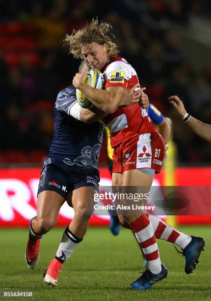 Billy Twelvetrees of Gloucester Rugby is tackled by Mark Jennings of Sale Sharks during the Aviva Premiership match between Sale Sharks and...