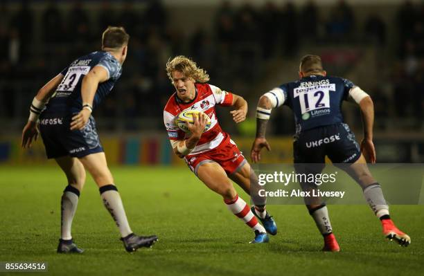 Billy Twelvetrees of Gloucester Rugby runs at Sam James and Mark Jennings of Sale Sharks during the Aviva Premiership match between Sale Sharks and...