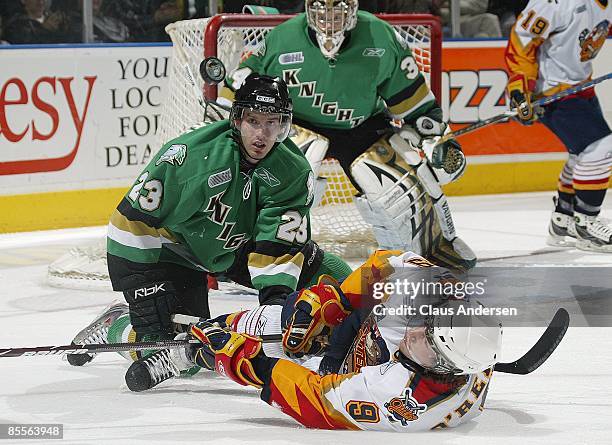 Kevin Montgomery of the London Knights keeps an eye on a puck deflected by a sprawling Ryan O'Reilly of the Erie Otters in game one of the opening...
