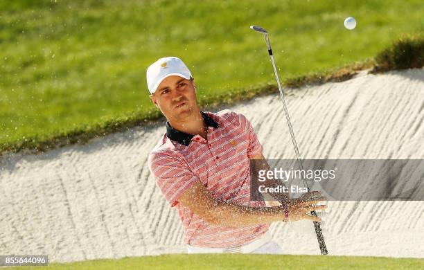 Justin Thomas of the U.S. Team makes a shot from a bunker on the 14th hole during Friday four-ball matches of the Presidents Cup at Liberty National...