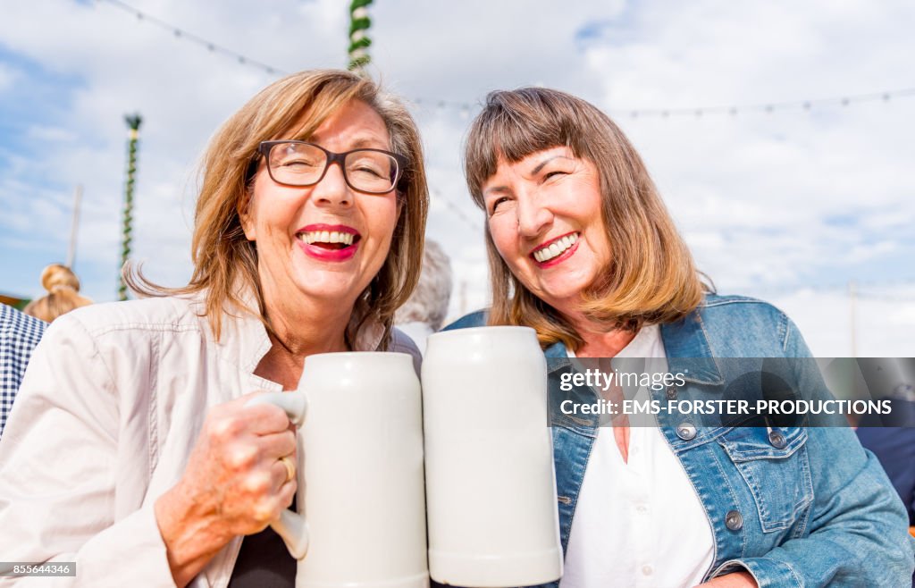 Two retired active senior pensioners enjoying time together while visiting Beer Fest in Munich.