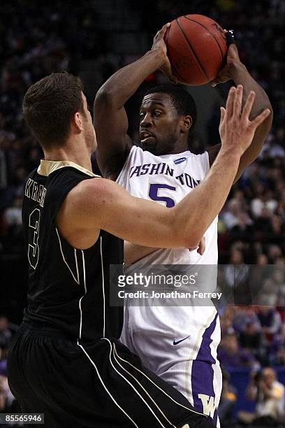 Justin Dentmon of the Washington Huskies moves the ball as he is guarded by Chris Kramer of the Purdue Boilermakers during the second round of the...