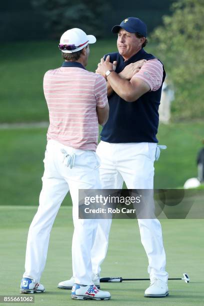 Phil Mickelson and Kevin Kisner of the U.S. Team celebrate on the 18th green after going one up against Marc Leishman and Jason Day of Australia and...