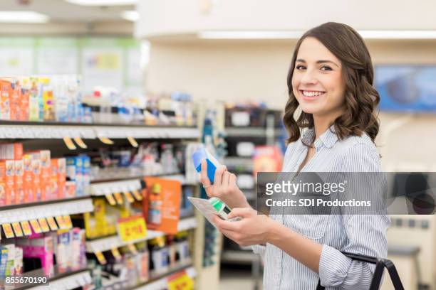 confident woman shops for allergy medicine in a pharmacy - happy customer grocery stock pictures, royalty-free photos & images