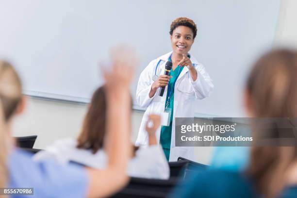 female doctor teaches a class at medical school - showing stock pictures, royalty-free photos & images