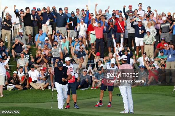 Phil Mickelson and Kevin Kisner of the U.S. Team celebrate on the 18th green after going one up against Marc Leishman and Jason Day of Australia and...