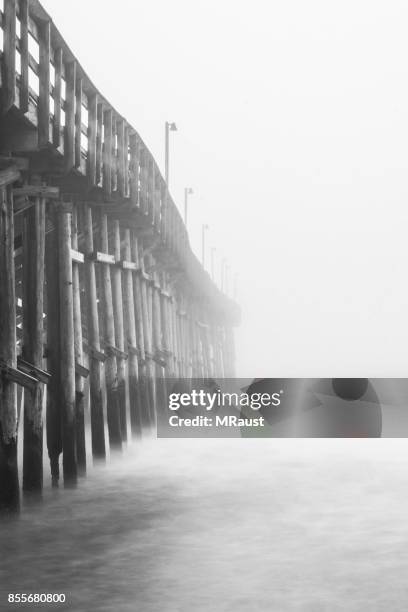 pier in the fog - grey pier stock pictures, royalty-free photos & images