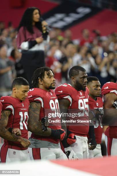 Brittan Golden, Robert Nkemdiche and Rodney Gunter of the Arizona Cardinals link arms during the natioanl anthem for the NFL game against the Dallas...