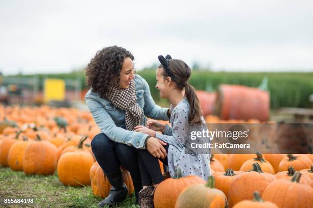 moeder en dochter op pompoen patch boerderij - asian mother and daughter pumpkin stockfoto's en -beelden