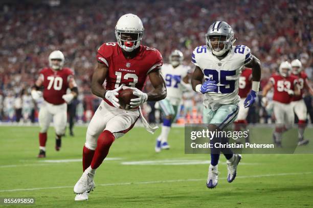 Wide receiver Jaron Brown of the Arizona Cardinals attempts to score a touchdown ahead of safety Xavier Woods of the Dallas Cowboys during the NFL...