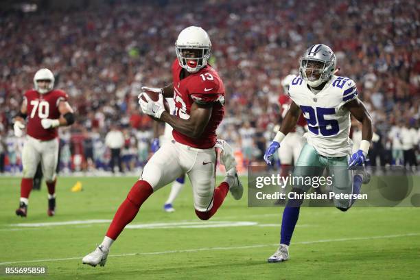 Wide receiver Jaron Brown of the Arizona Cardinals attempts to score a touchdown ahead of safety Xavier Woods of the Dallas Cowboys during the NFL...