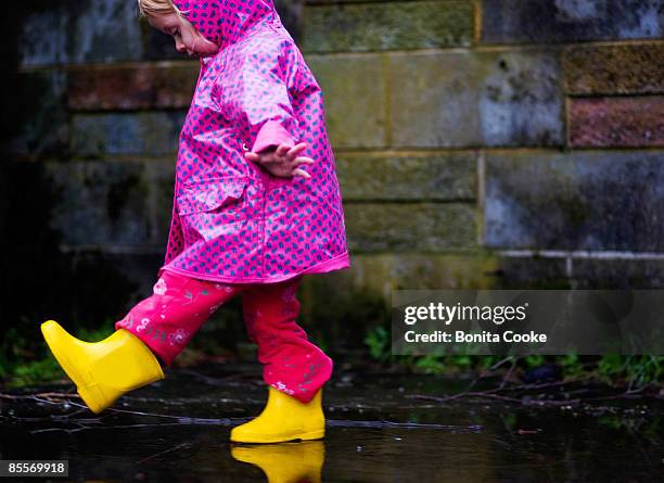 puddle fun - raincoat stock pictures, royalty-free photos & images
