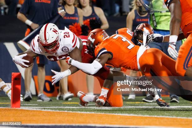 Devine Ozigbo of the Nebraska Cornhuskers dives for the touchdown as Del'Shawn Phillips of the Illinois Fighting Illini tries to make the stop at...