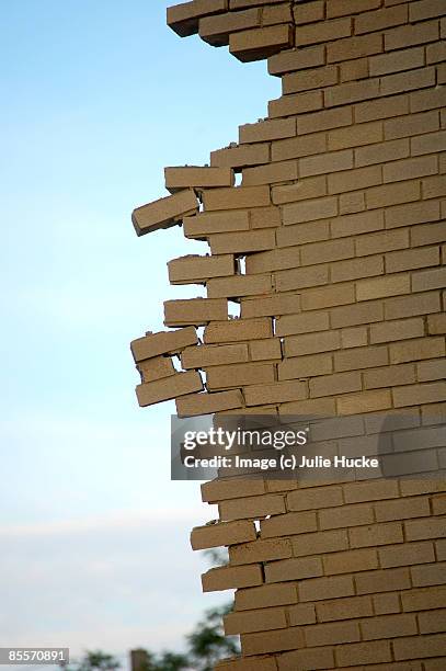 crumbling brick wall against blue sky - casser mur photos et images de collection