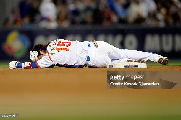 Yong-Kyu Lee of Korea lies on the field after clashing with shortstop Hiroyuki Nakajima of Japan after tying to steal second base in the sixth inning...