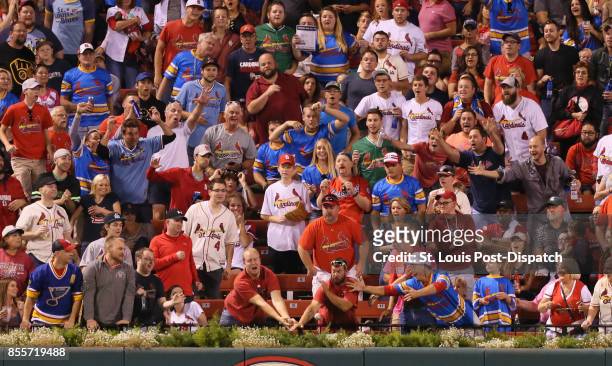 Fans in the outfield reach for solo home run ball hit by the St. Louis Cardinals' Paul DeJong in the fourth inning against the Milwaukee Brewers on...