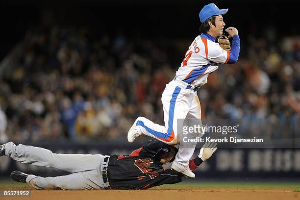 Young Min Ko of Korea turns the double play against Hiroyuki Nakajima Japan to end the seventh inning in the finals of the 2009 World Baseball...