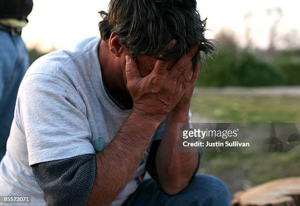 Keith Day holds his head in his hands as he sits outside of his tent at a homeless tent city March 23, 2009 in Sacramento, California. Sacramento...