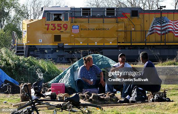 Train passes by homeless people at a homeless tent city March 23, 2009 in Sacramento, California. Sacramento mayor Kevin Johnson announced plans to...