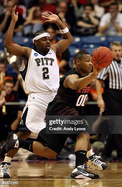 Byron Eaton of the Oklahoma State Cowboys handles the ball against Levance Fields of the Pittsburgh Panthers during the second round of the NCAA...