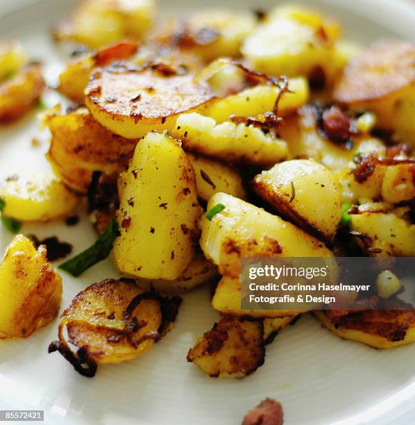 roasted potatoes on white plate - corinna haselmayer stockfoto's en -beelden