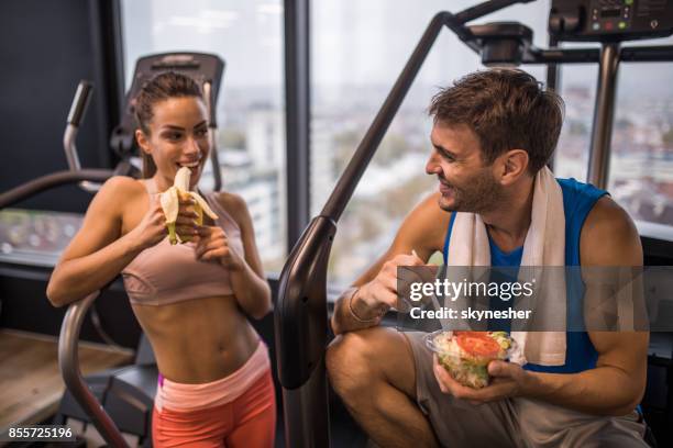 felice coppia atletica che mangia cibo sano durante una pausa in palestra. - sportman foto e immagini stock