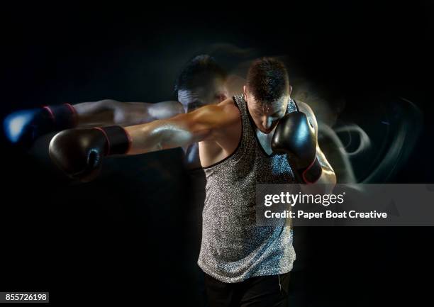 boxer with big arms wearing a gray tank top, doing some jab punches with very fast motion - fast motion stock pictures, royalty-free photos & images