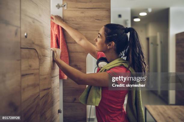 young athletic woman taking her clothes in the locker room. - locker room stock pictures, royalty-free photos & images