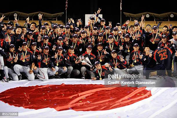 Ryozo Kato Japanese baseball commissioner holds the championship trophy as he poses with team Japan after defeating Korea during the finals of the...