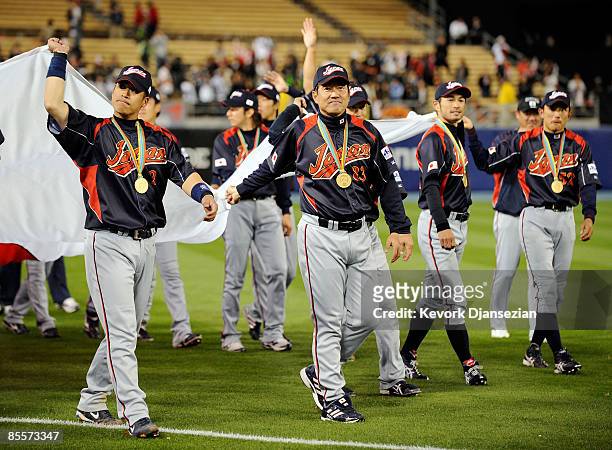 Manager Tatsunori Hara of Japan and his tam carry their nation's flag after defeating Korea, 5-3, during the finals of the 2009 World Baseball...
