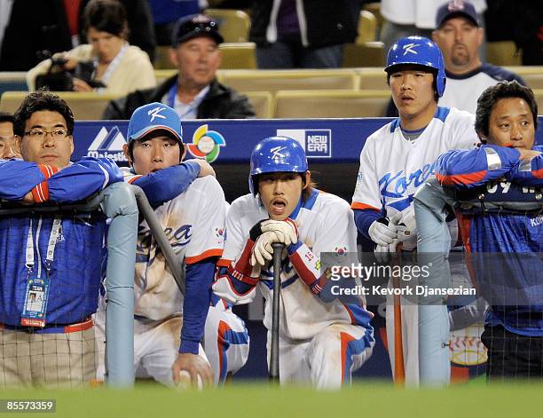 Yong-Kyu Lee of Korea and teammates look on from the dugout in the tenth inning of the finals of the 2009 World Baseball Classic against Japan on...