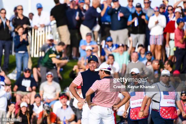 Phil Mickelson and Kevin Kisner of the U.S. Team celebrate their 1 up victory with a dance on the 18th hole green during Friday Four-Ball matches on...