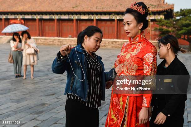 Bride is getting ready for the photo session at Halberd Gate near Tiananmen Square in Beijing ahead of the upcoming National Day and the Golden Week...