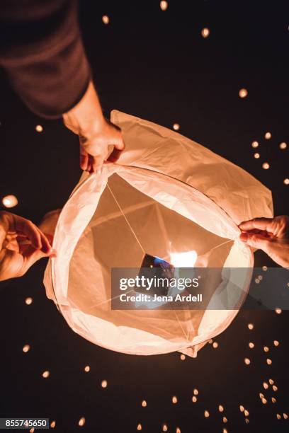 friends releasing paper lantern in sky - personal perspective festival stock pictures, royalty-free photos & images