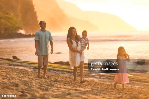 hawaiian familie wandeling op het strand bij zonsondergang - fat guy on beach stockfoto's en -beelden