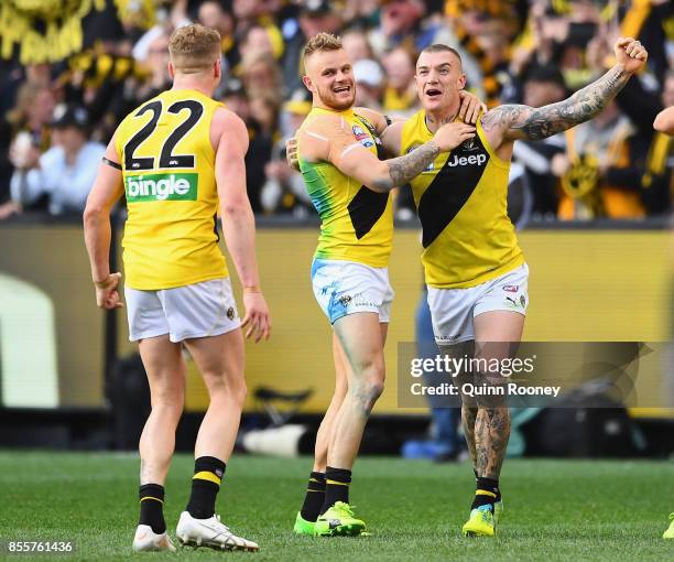 Josh Caddy, Brandon Ellis and Dustin Martin of the Tigers celebrate winning the 2017 AFL Grand Final match between the Adelaide Crows and the...