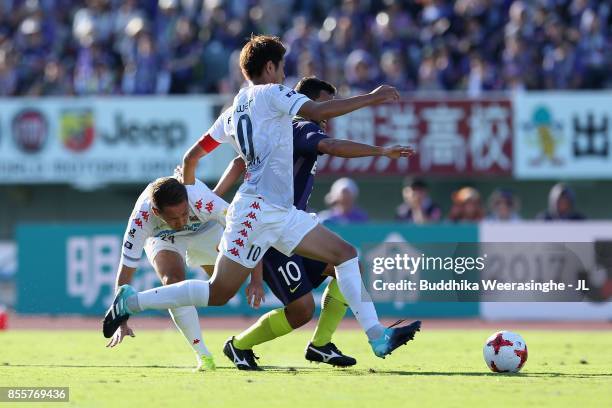 Felipe Silva of Sanfrecce Hiroshima controls the ball under pressure of Akito Fukumori and Hiroki Miyazawa of Consadole Sapporo during the J.League...