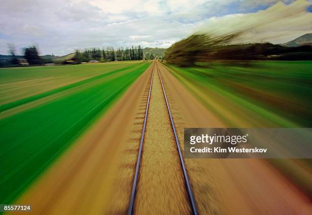 railway track through countryside, blurred motion - westerskov stock pictures, royalty-free photos & images