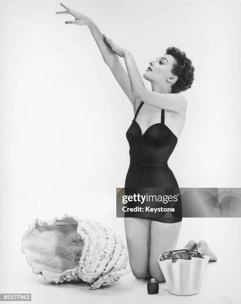 Actress Donna Wallace applies sun tan lotion before a day on the beach, circa 1950.