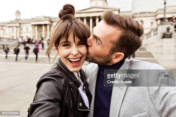 happy couple taking selfie in front of national gallery in london - casal beijando na rua imagens e fotografias de stock